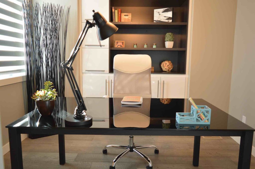 A neat and tidy home office with lighting, plants and an organized desk