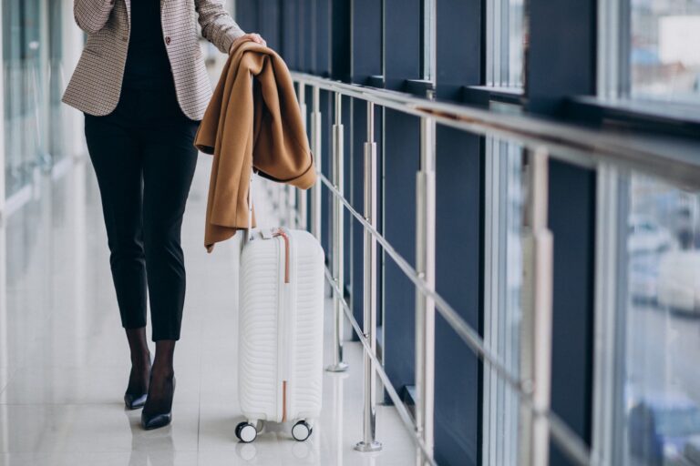 Business woman in airport terminal with travel bag