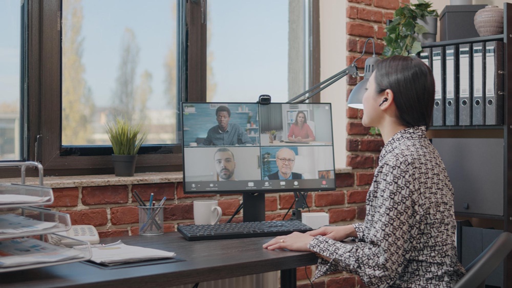 Business woman talking to colleagues on online video call, doing teamwork on project planning