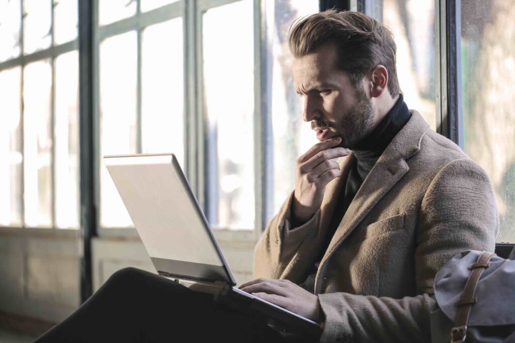Businessman looking contemplatively at his laptop