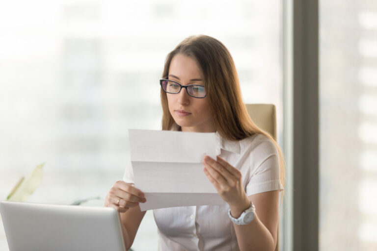 Businesswoman reading official document at workplace