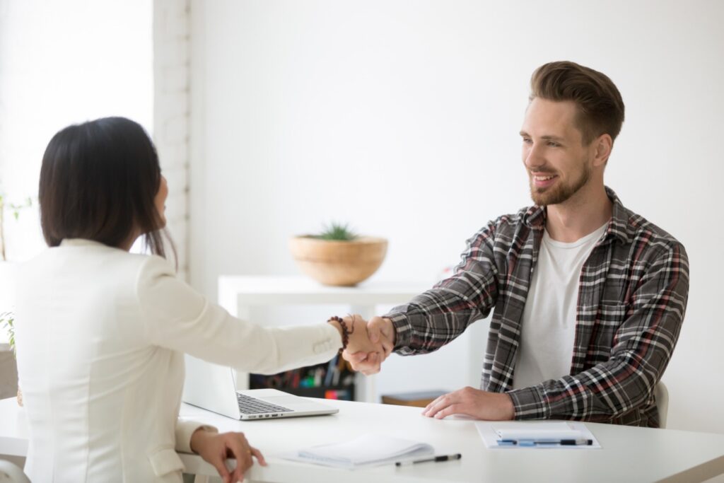 Customer service manager shakes hands with a customer in his office