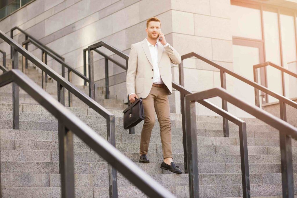 Employee leaving office while on phone, wearing professional business attire