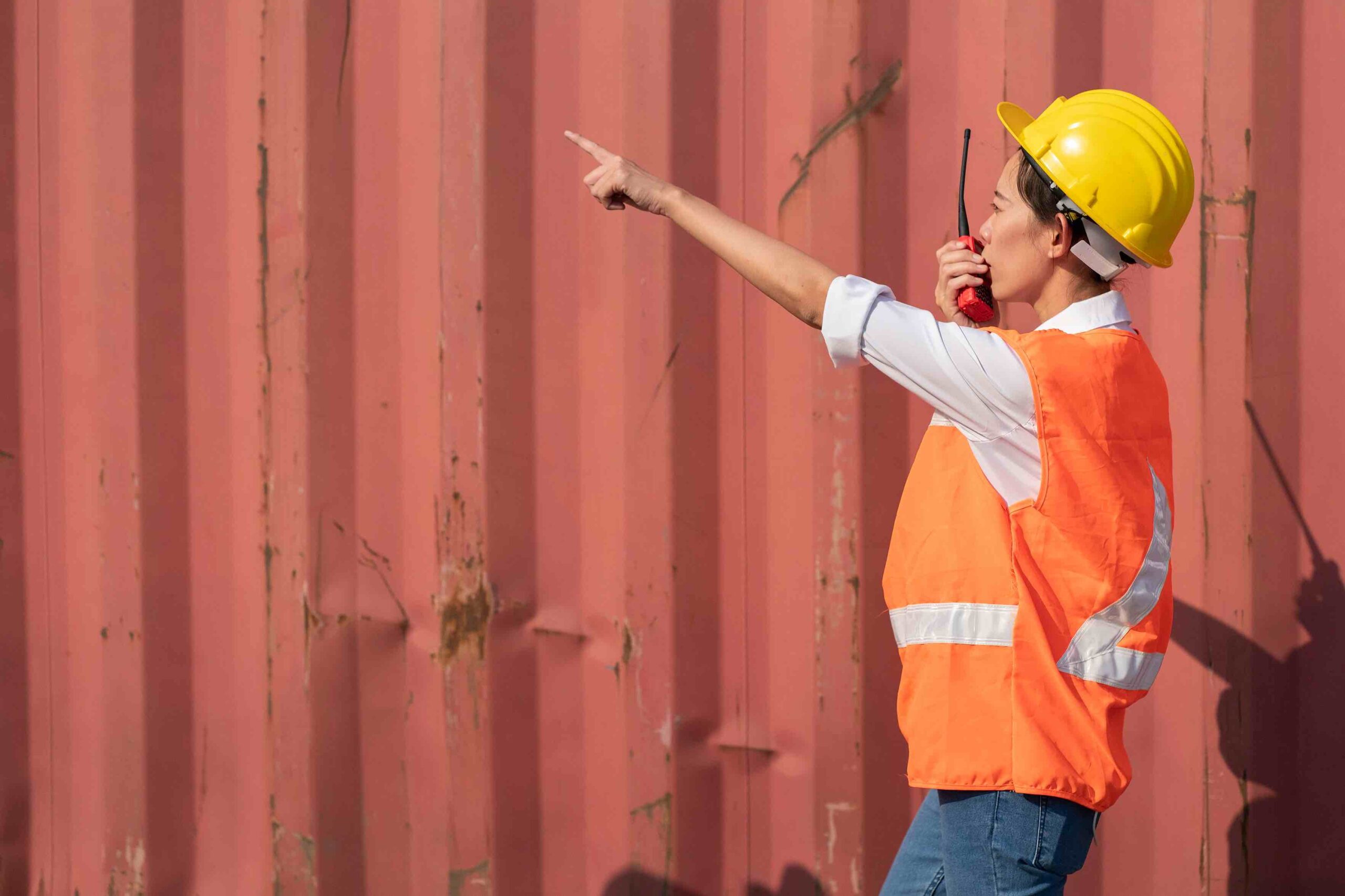 Female construction project manager wearing a uniform, carrying a walkie-talkie for communication