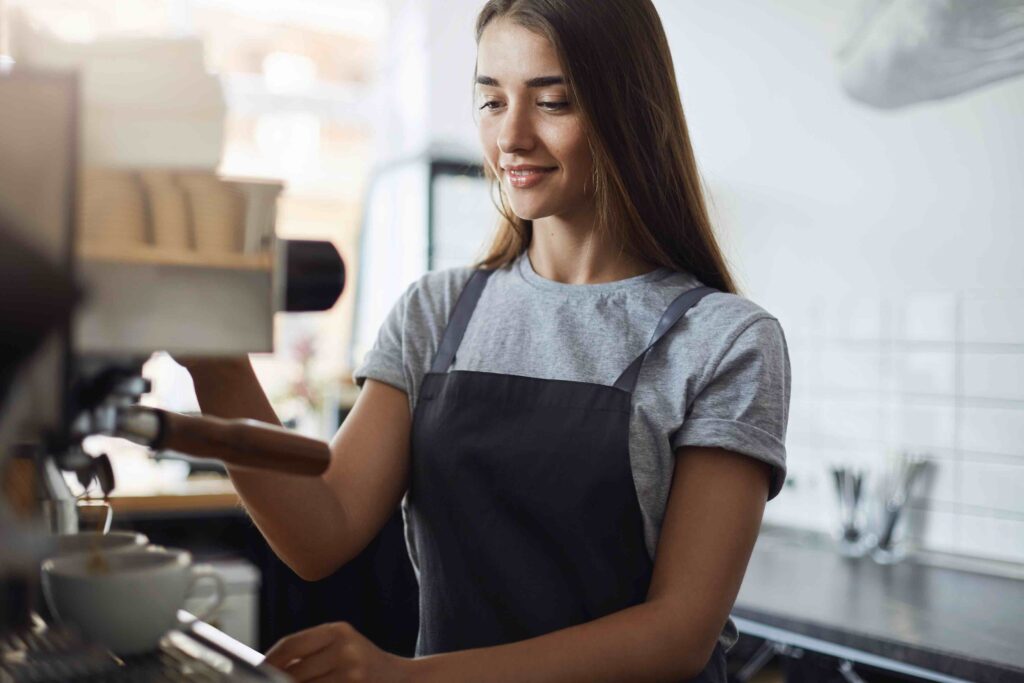 Female student on her summer job as coffee maker in on site pastry shop