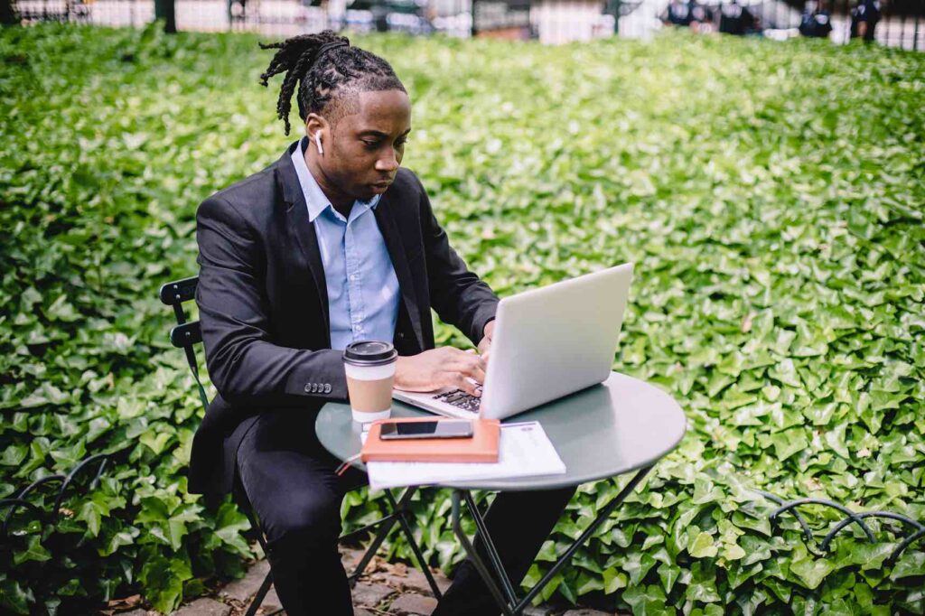 Financial professional working on his laptop outdoors