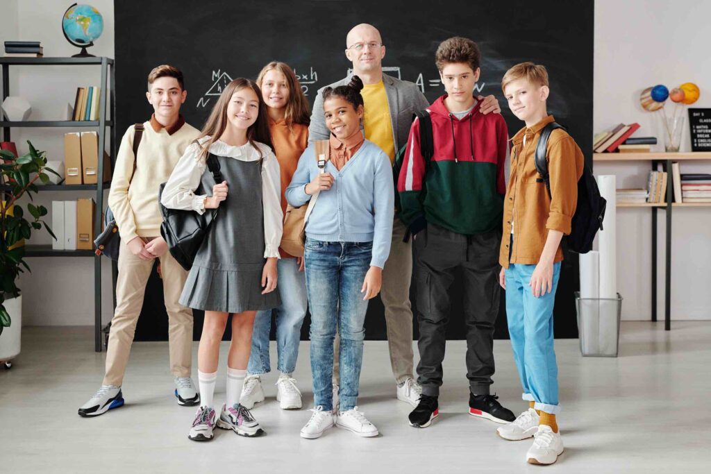 Group of students with their teacher in front of the blackboard