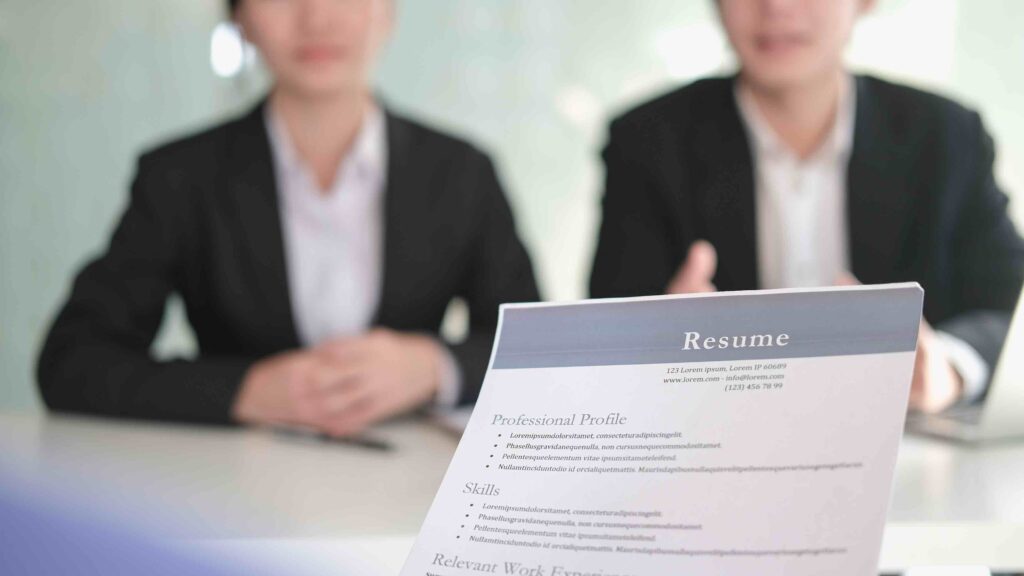 Person presenting their resume to two hiring managers