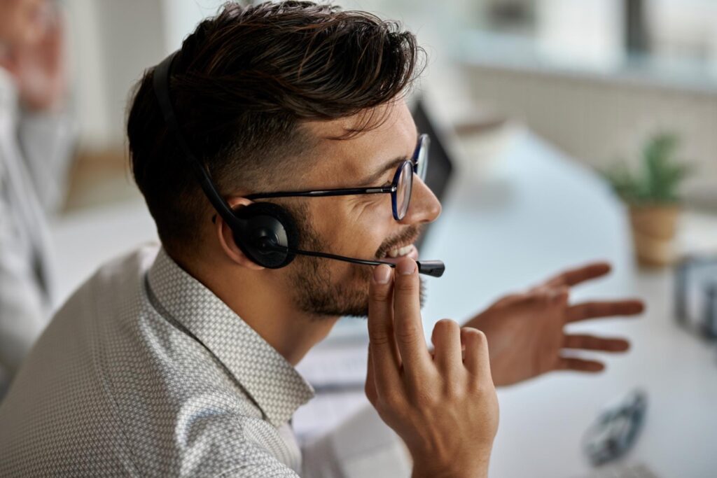 Happy HR assistant at work talking on phone through headset