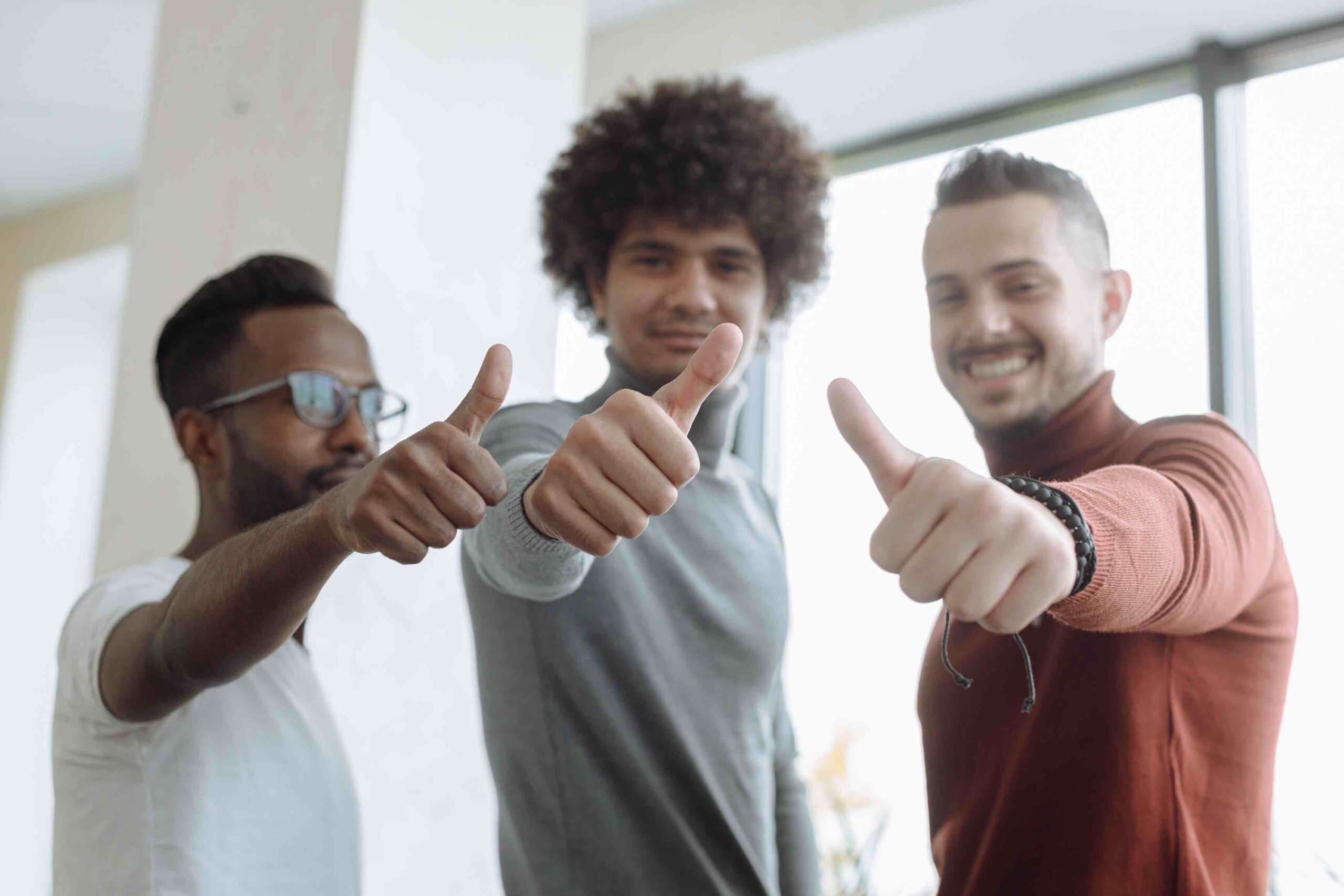 Happy colleagues who give the thumbs up and enjoy their working lives