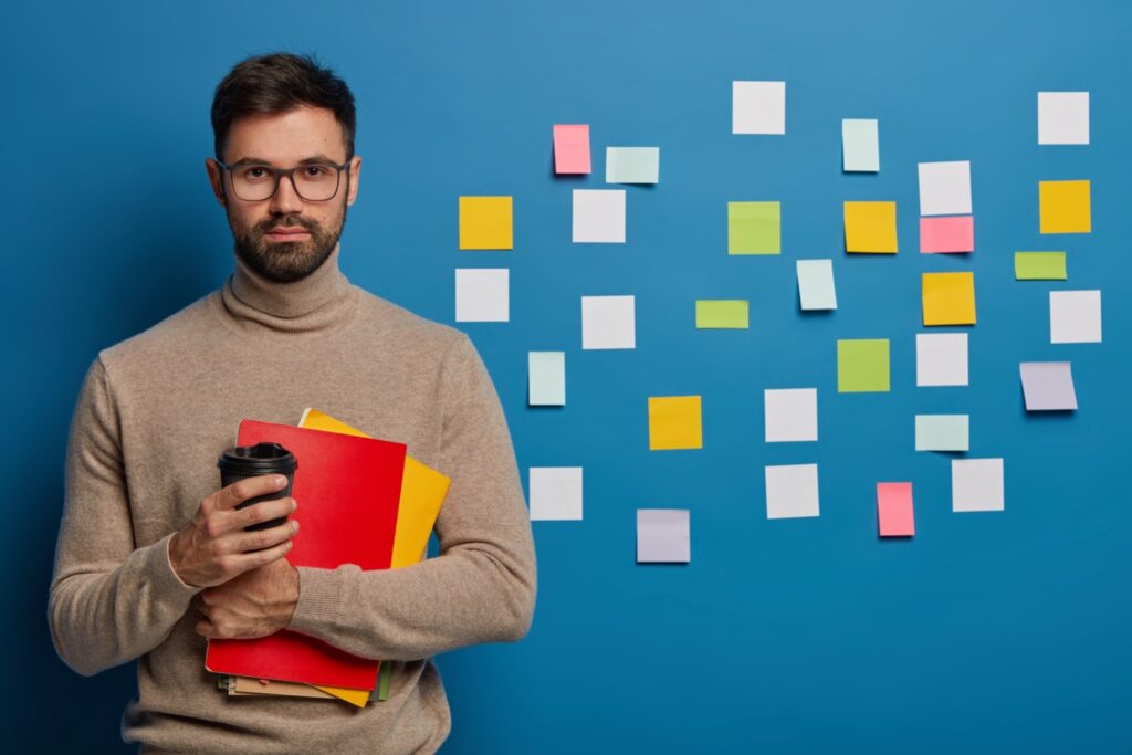 Job applicant putting stickers on the wall to identify his key strengths and writing them down there