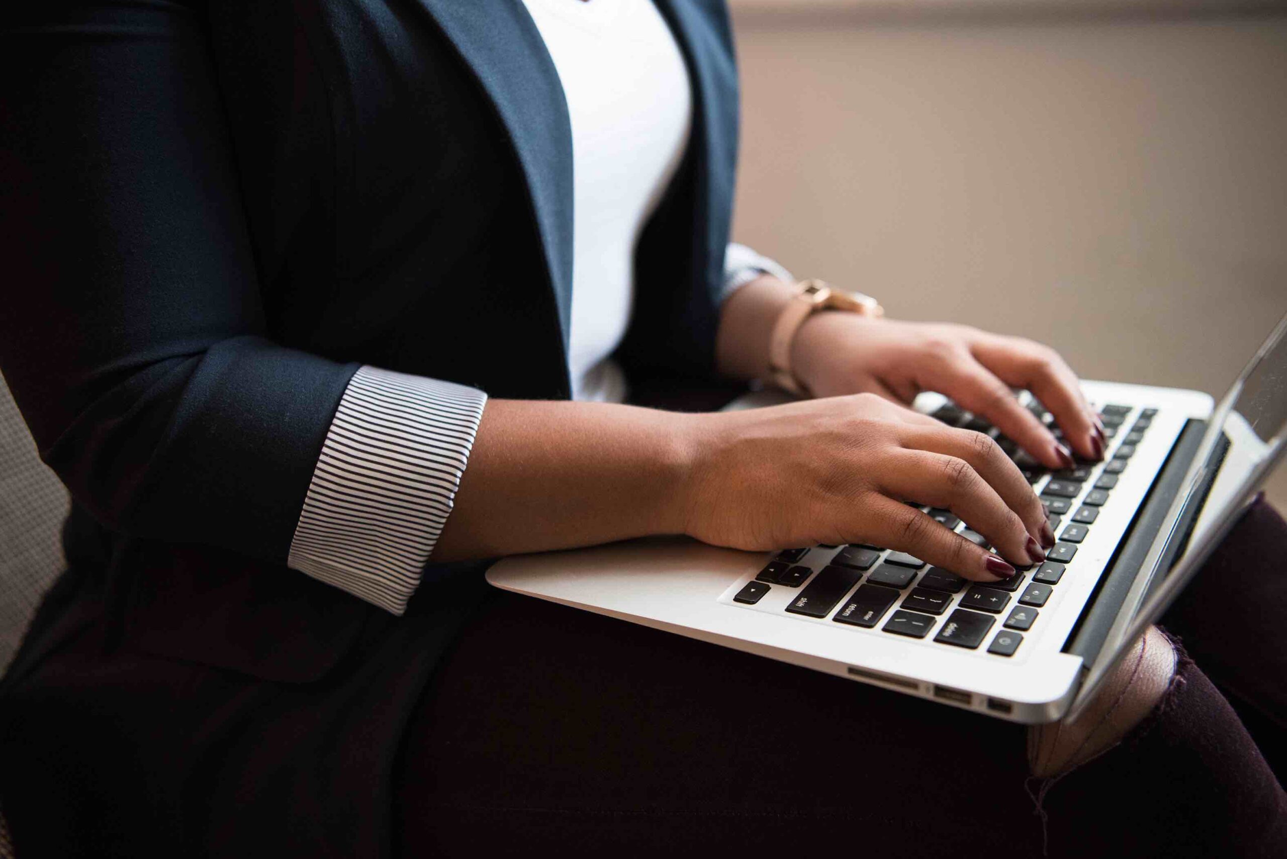 Job applicant typing resume and cover letter on her laptop