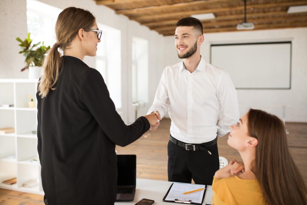 Joyful male job applicant shaking hand of hiring manager at the end of a job interview