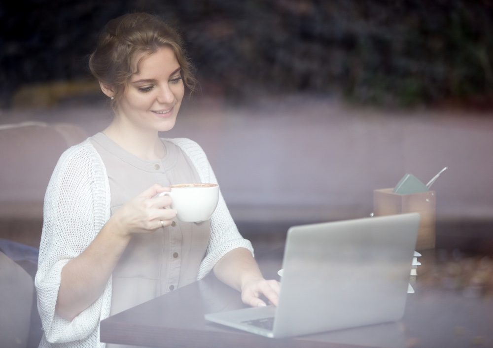 Modern woman working on laptop in coffee shop