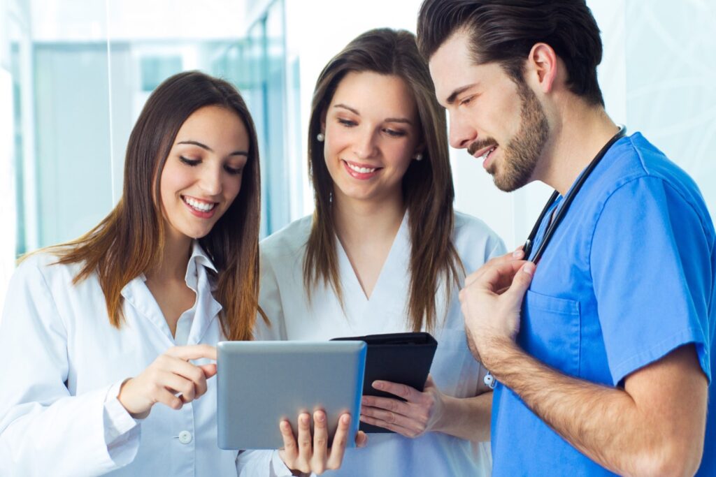 Nursing team chatting and looking at patient records on tablet