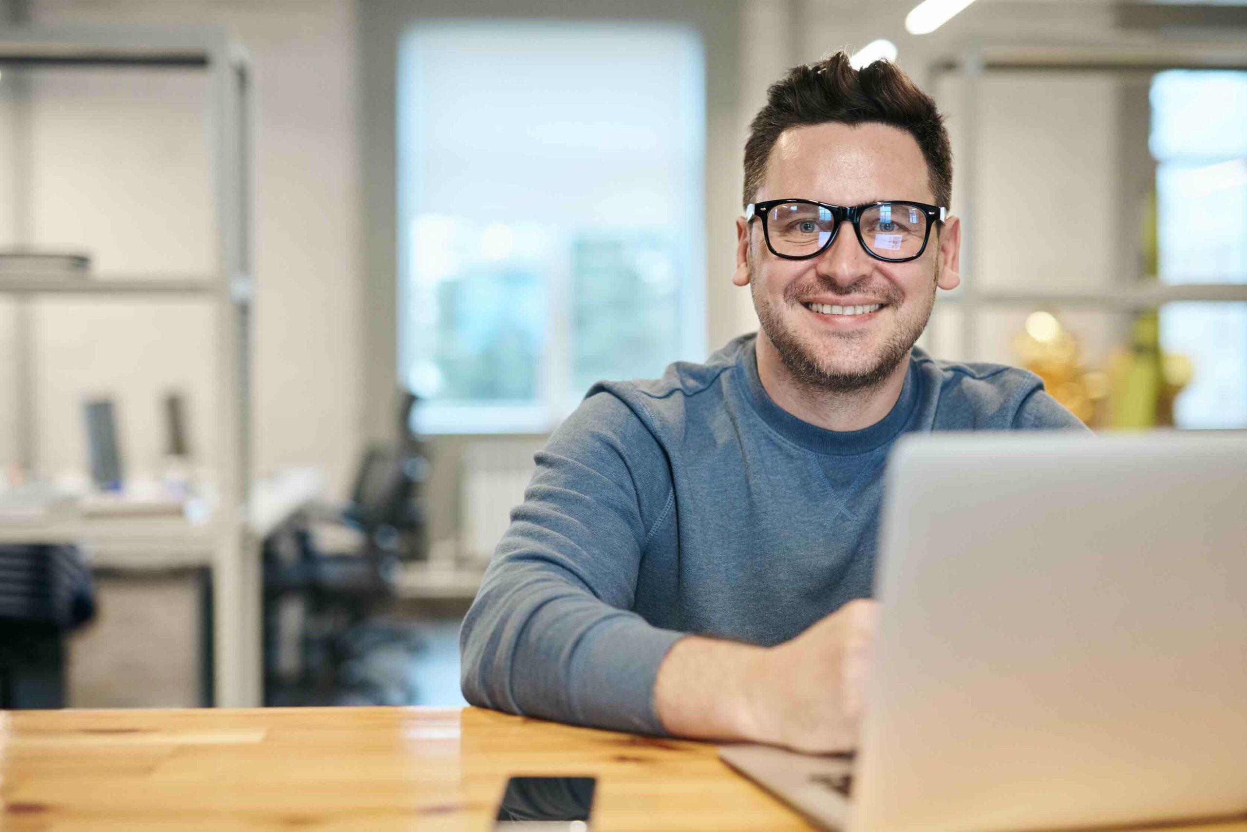 Office worker at desk thinking about his SMART goals