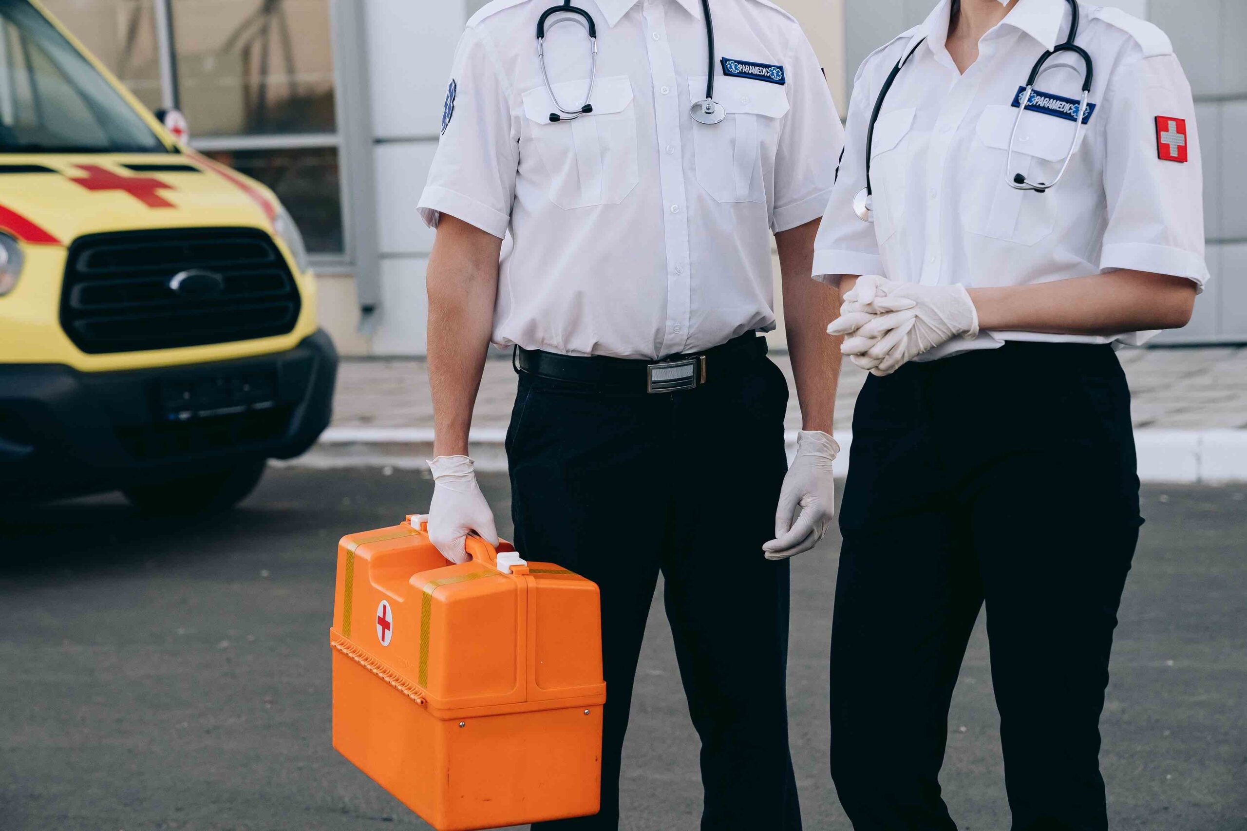 Paramedics wearing white gloves with first aid kit