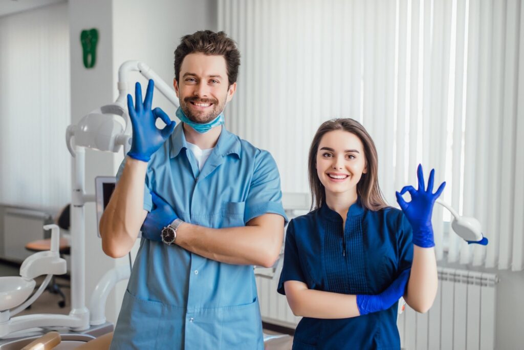 Photo of smiling dental hygienists with okay sign