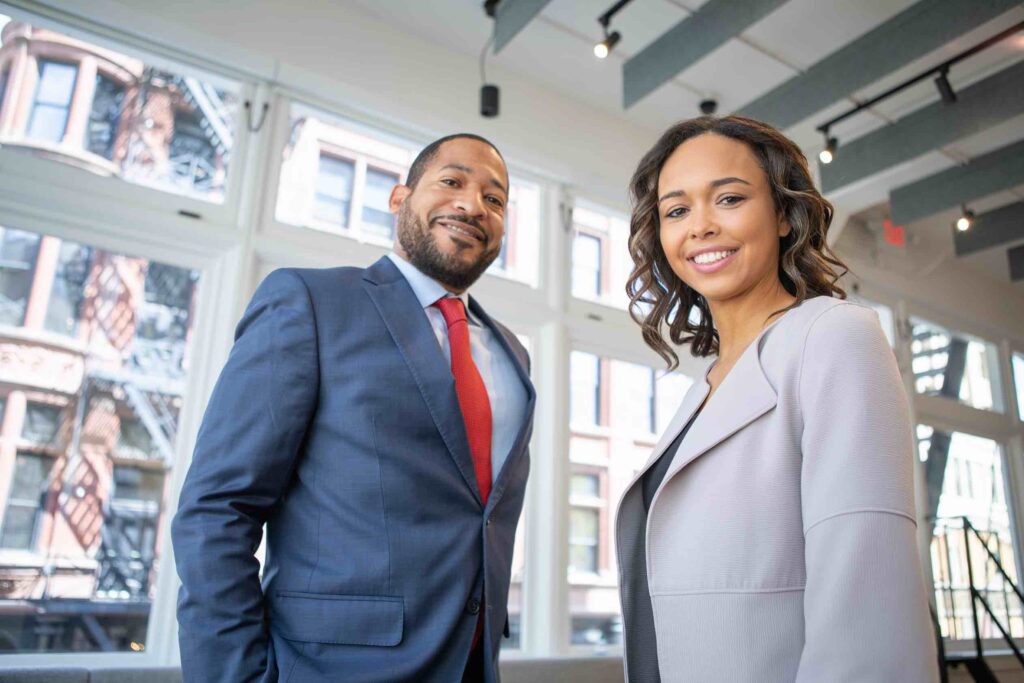 Portrait of two business professionals smiling into camera