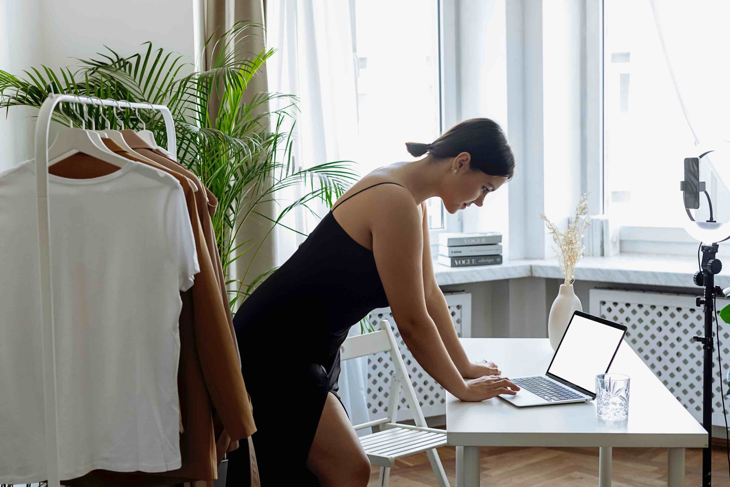 Remotely working woman in her apartment looking at her laptop