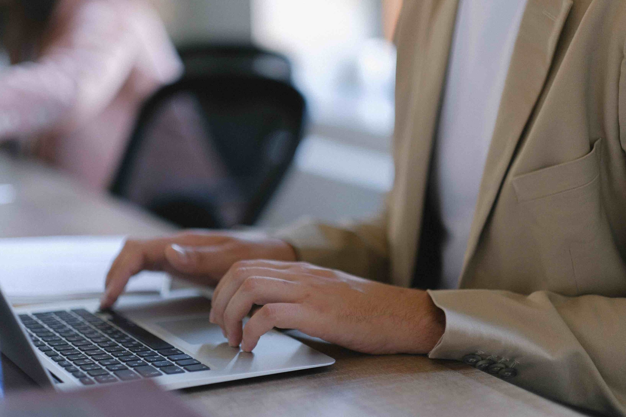 Sales manager typing information about product lines on his laptop