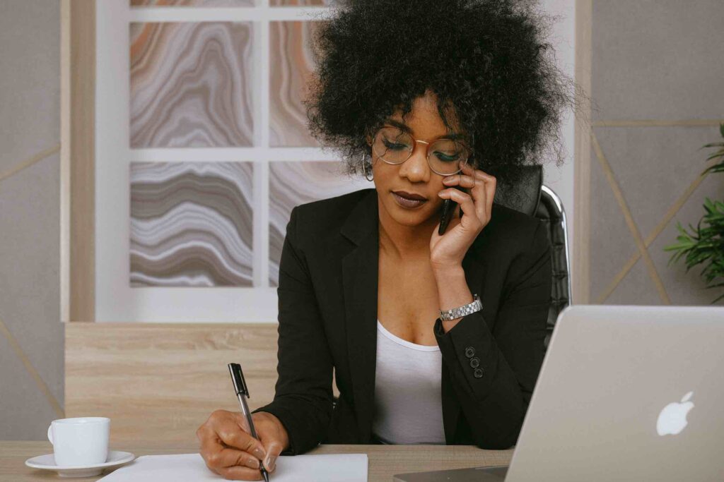 Sales executive speaking on phone taking notes