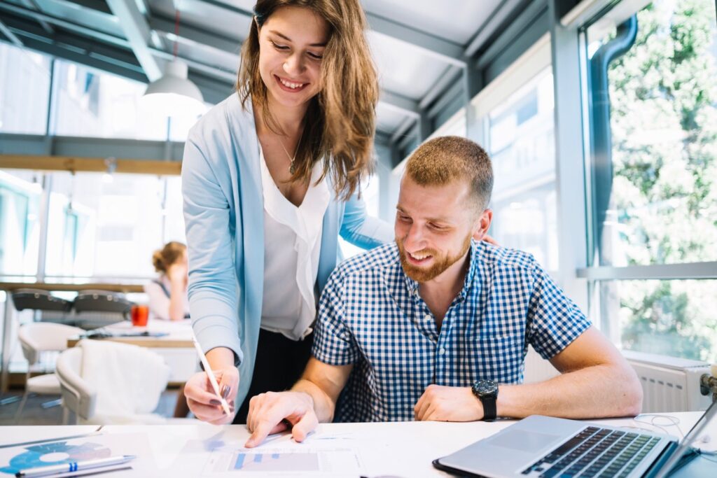 Smiling colleagues at work talking about project management