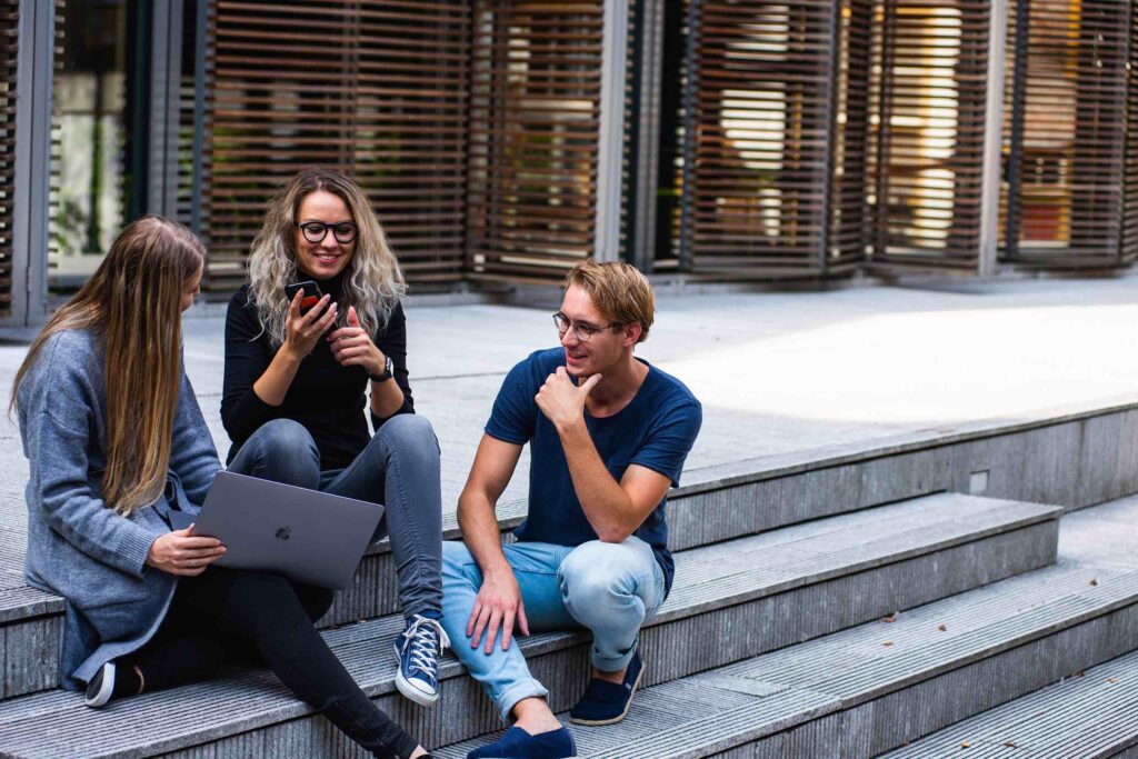 Students sitting on stairs in front of university building