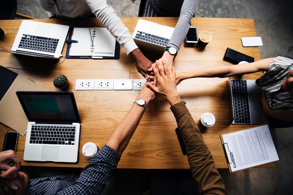 Team of diverse business people stacking hands during meeting