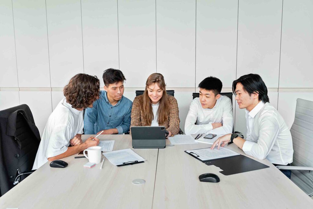 Team of financial analysts working together at desk in meeting room