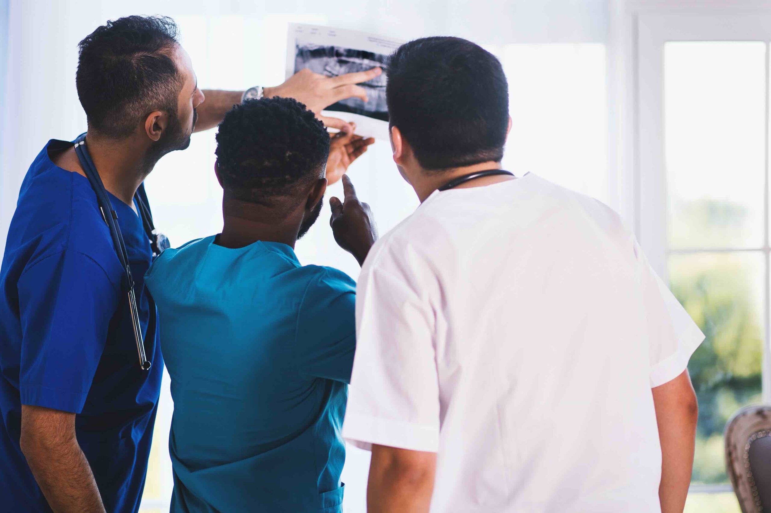 Three medical staff members check the X-ray result