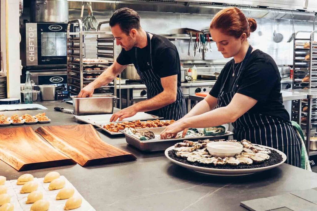 Two food service workers at work in kitchen