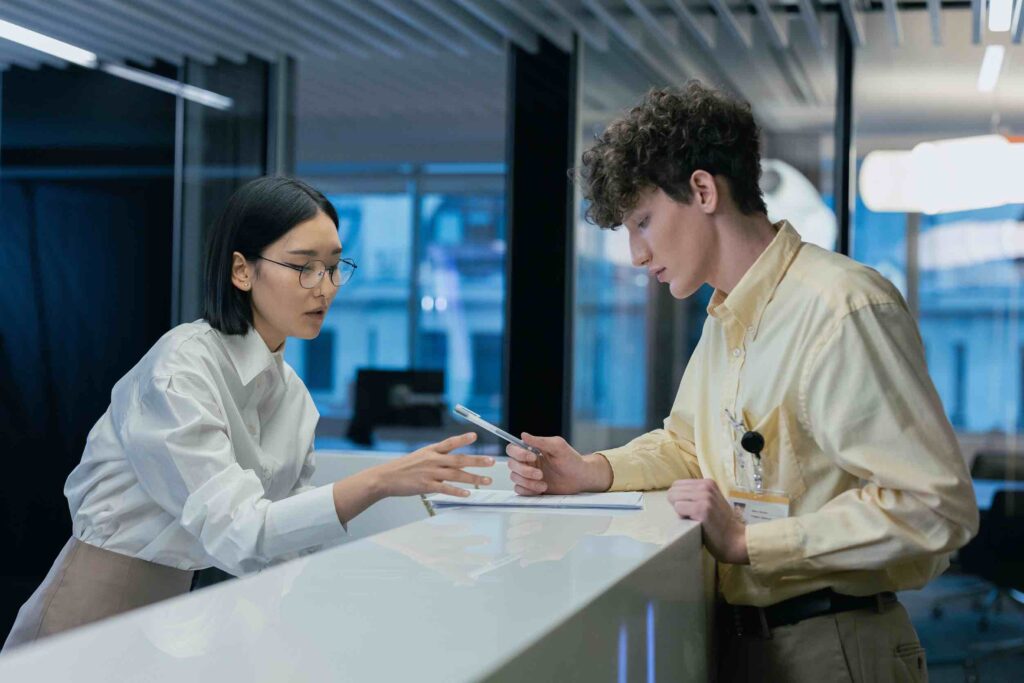 Two professionals working in a hotel and reviewing some files