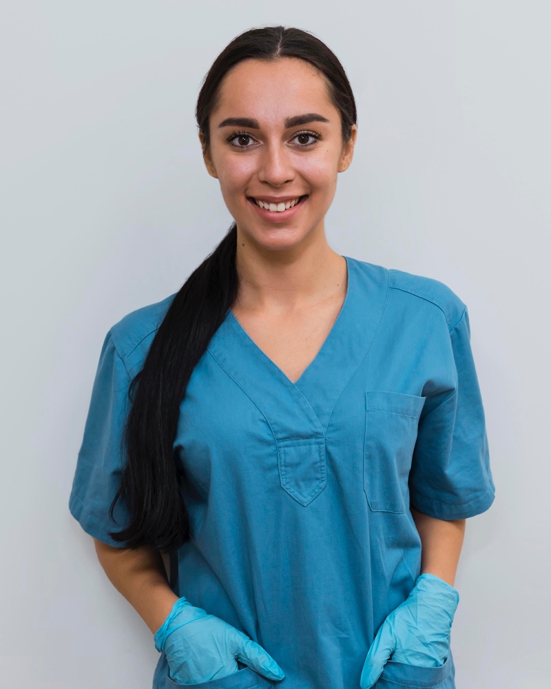 Smiling young certified nursing assistant at work about to do patient care