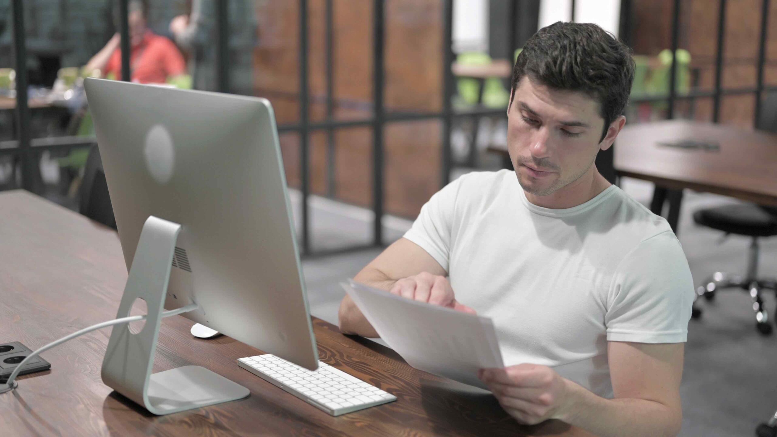 Male data entry professional in front of his computer reviewing data in spreadsheet