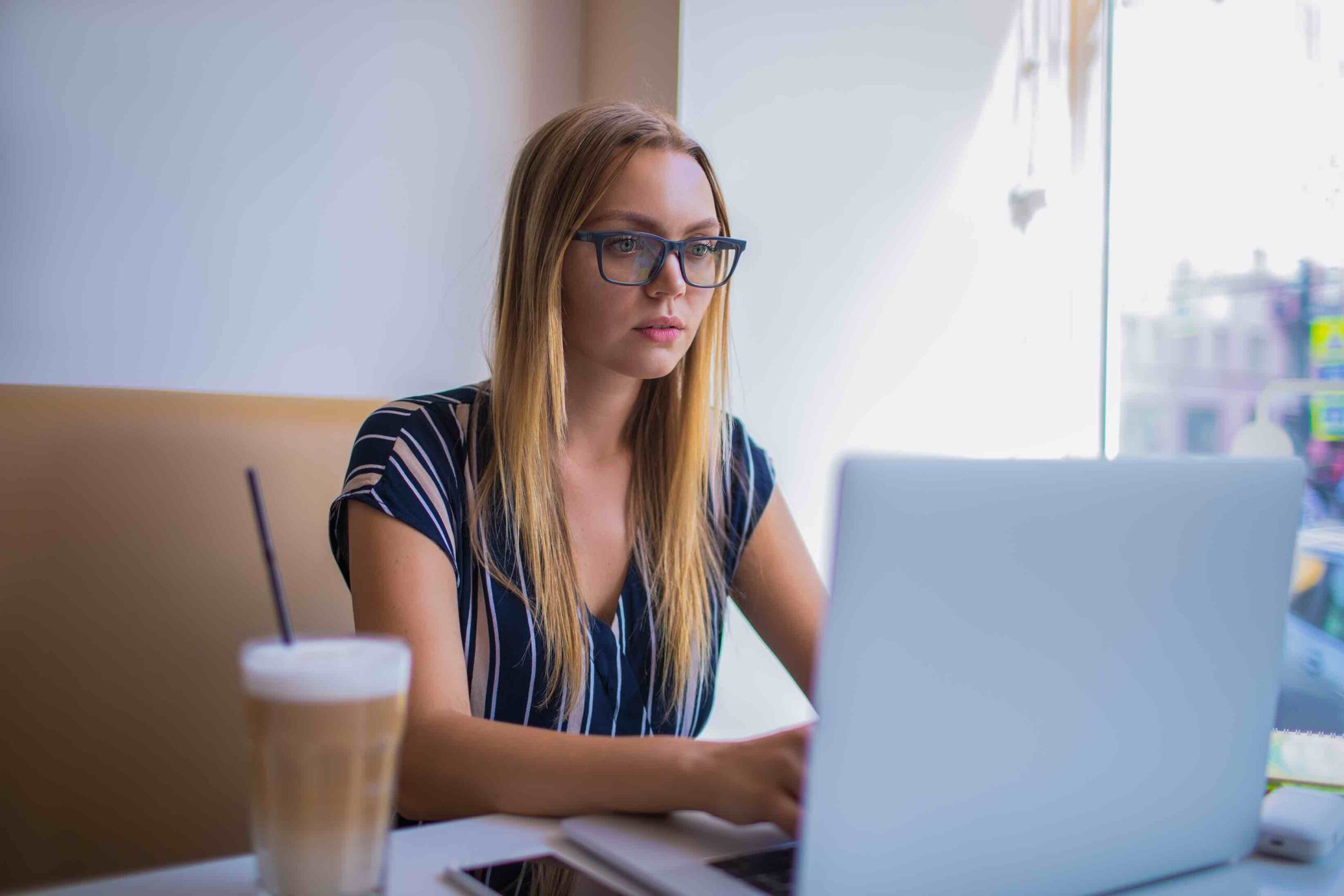 Young data analyst checking job ad about to use a resume builder for her CV