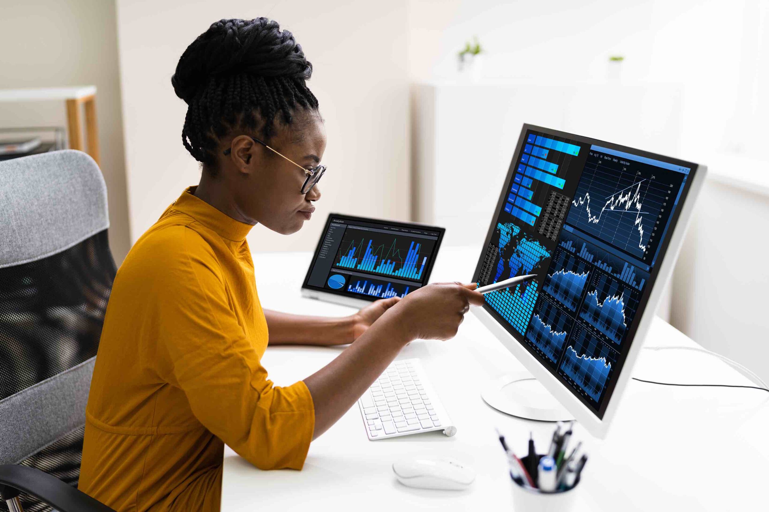 Female marketing data analyst at work reviewing charts on her computer