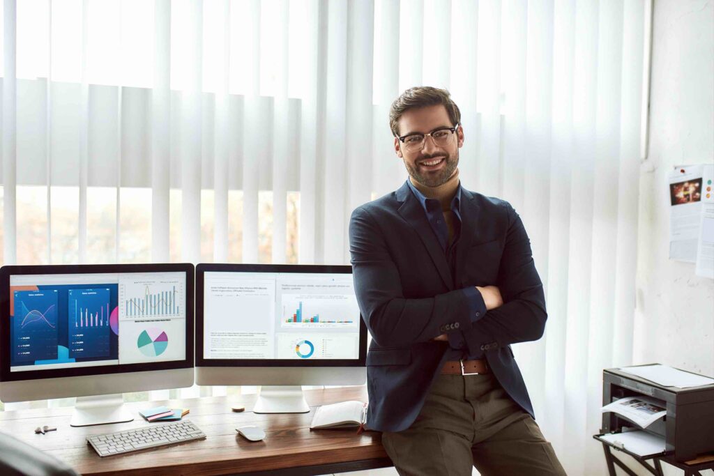 Male financial data analyst proficient in risk management in front of his desk