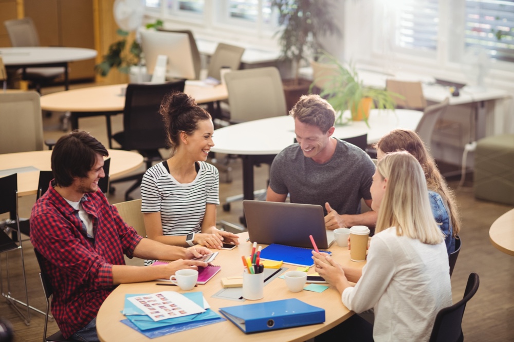 Graphic designers in a meeting showing a positive attitude and the ability to communicate effectively