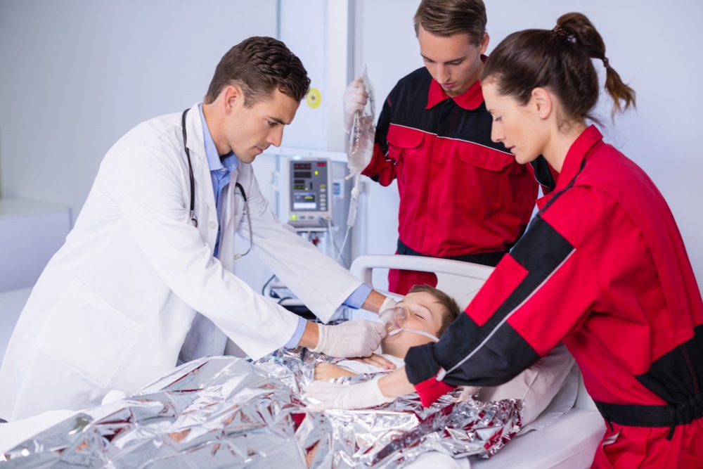 Doctor and paramedic examining a patient in emergency room