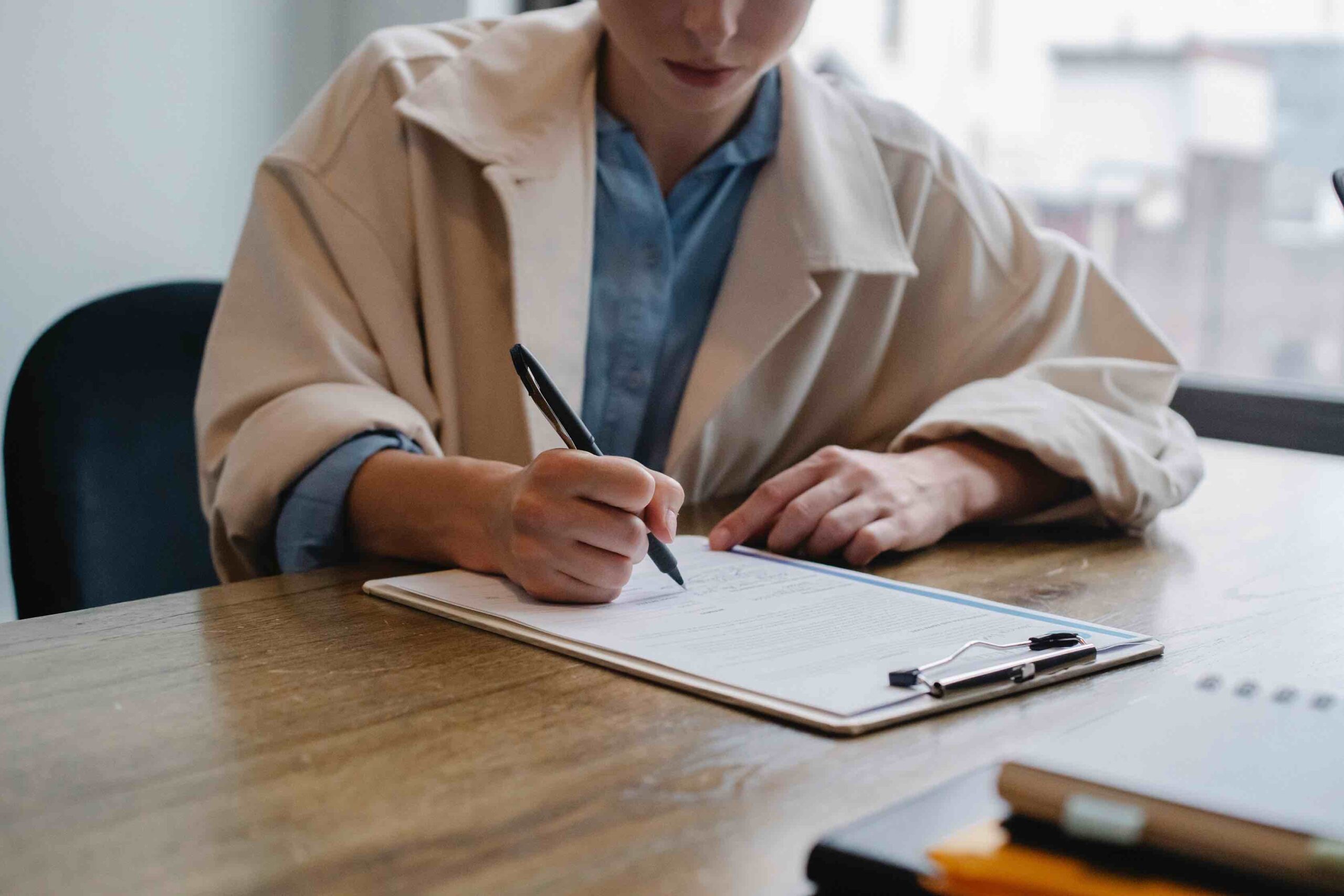 Woman signing a certificate on clipboard