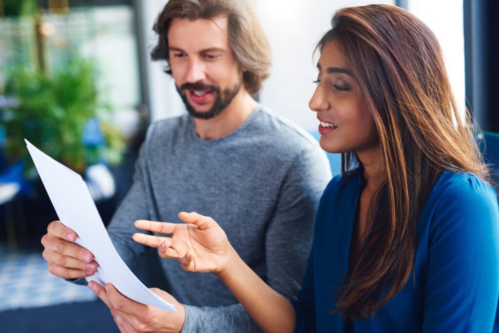 Young adults coworkers analyzing document