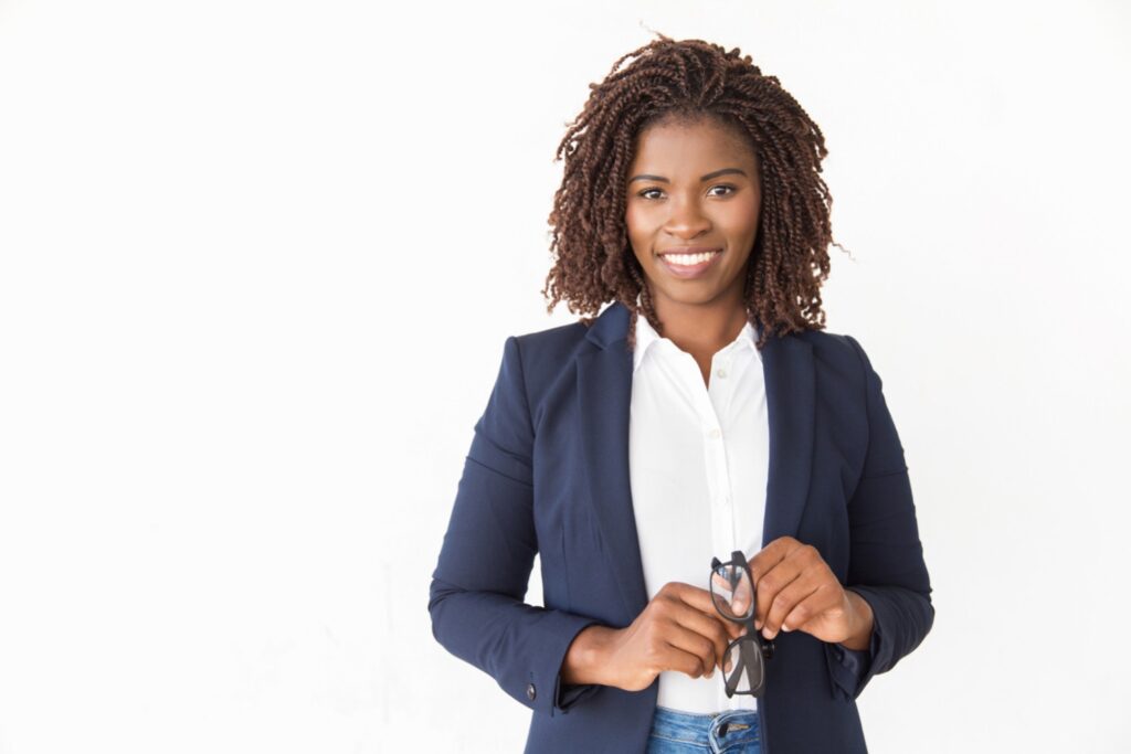 Young and confident professional smiling and holding her glasses