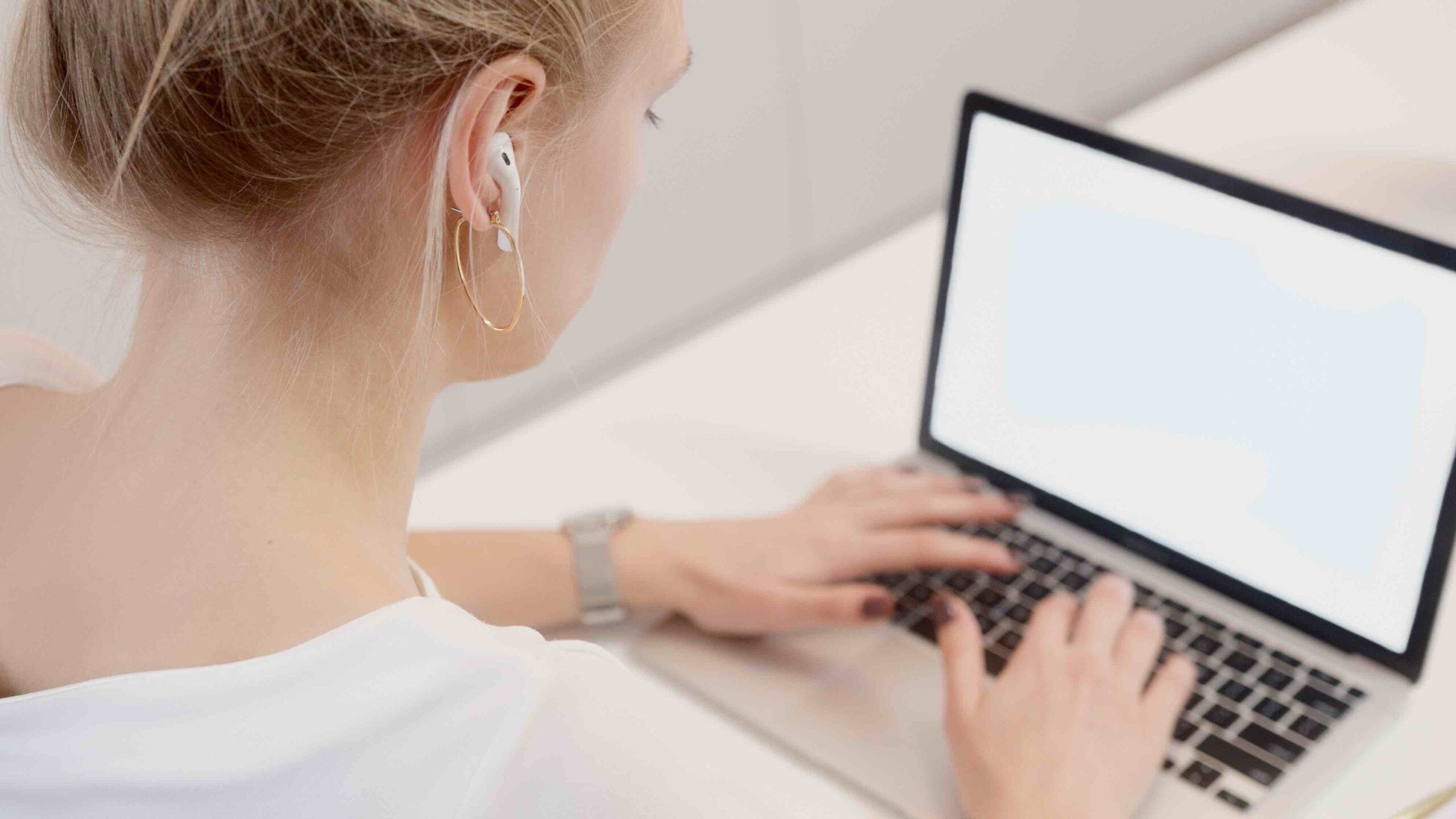 Young applicant typing a follow-up email to the hiring manager regarding her job application