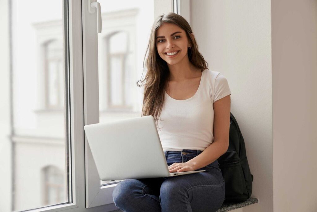 Young female employee sitting in windowsill just wrote an effective letter