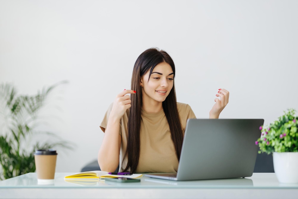 Young female student looking at laptop learning the basics on how to write a cover letter for an internship