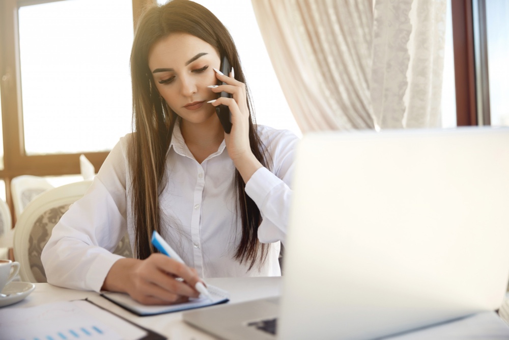 Young hiring manager is conducting a phone interview with potential candidates