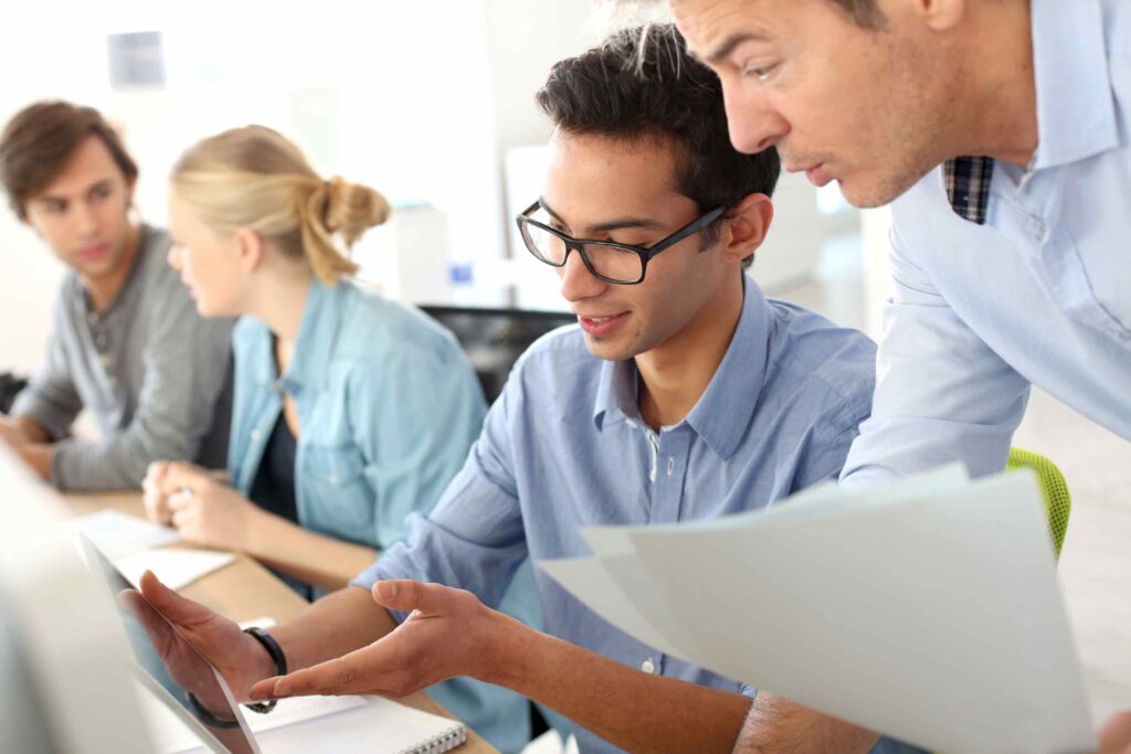 Young male college student improving his professional skills during an internship