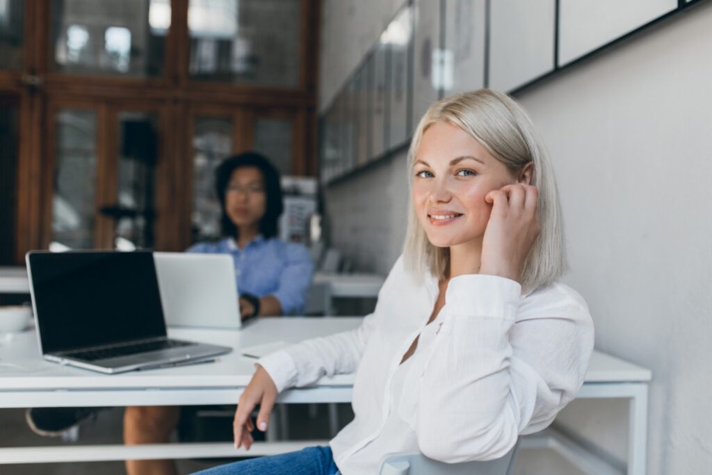 Young smiling software engineer sitting at her desk