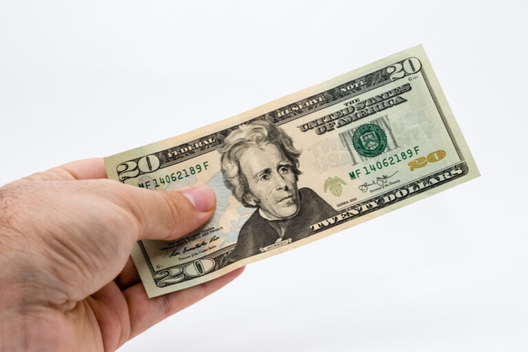 Closeup shot of a person holding a 20 dollar bill
